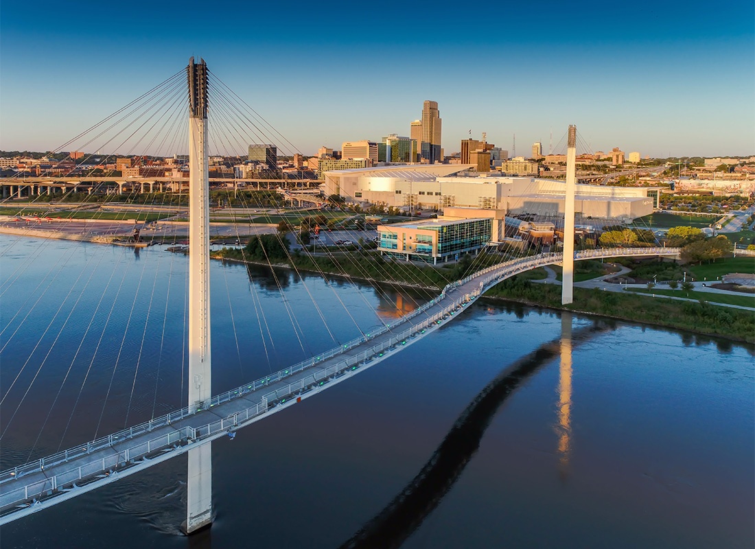 About Our Agency - Aerial View of a Steel Bridge Across the River Leading into Downtown Omaha Nebraska at Sunset